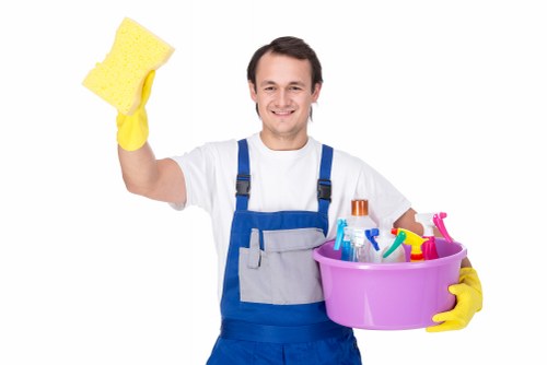 Domestic cleaner wiping kitchen surfaces in a local flat